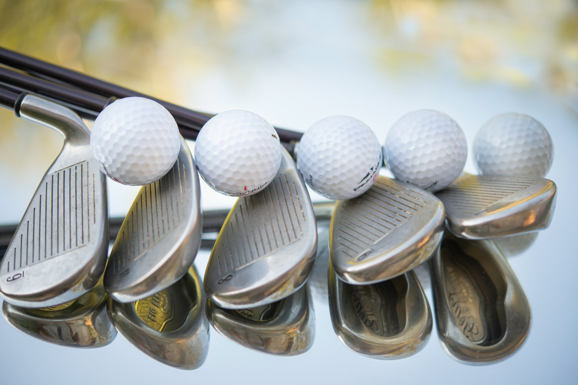 golf-clubs-golf-balls A group of golf clubs with golf balls balanced between them